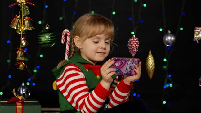 Young girl with a phone at Christmas. (Alamy)